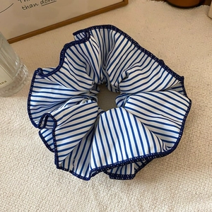 Détail d'un chouchou en dentelle à rayures bleues et blanches avec texture en lin fin