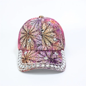 Detailed view of purple floral baseball cap with hand-set rhinestones and golden leaf print