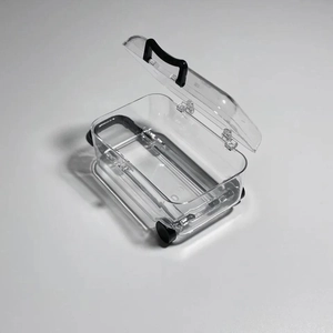 Macro shot of an open mini transparent jewelry box with a black handle and wheels