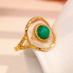 Detailed close-up of 18K gold hammered ring with green acrylic stone and white resin inlay