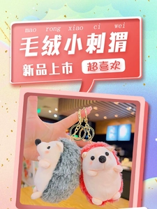 Detail of plush hedgehog keychain with soft fur, pink cheeks, and golden metal ring