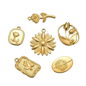 Macro view of six gold floral charms including rose and tulip for DIY jewelry making