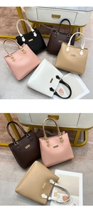 Close-up of five color variations of tote bags with dual-tone handles and metal accents