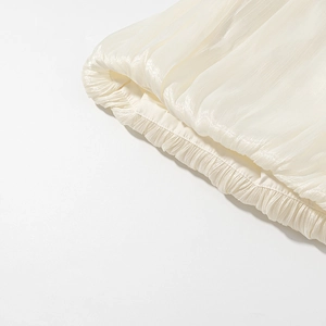 Macro shot of apricot satin fabric texture with gathered elastic pleat details