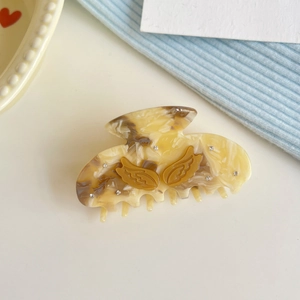 Elegant marbled acetate hair claw with golden wings and sparkling rhinestones