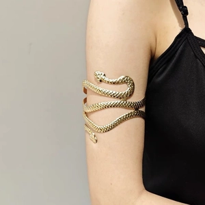 Detailed macro view of golden snake arm cuff with intricate scale texture and dual snake heads