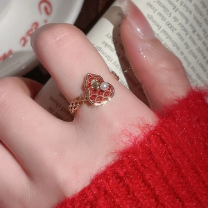 Close-up of a vintage 18k gold plated ring featuring a red gourd charm and white pearl