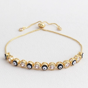 Detail of adjustable evil eye bracelet with cubic zirconia on white leather background