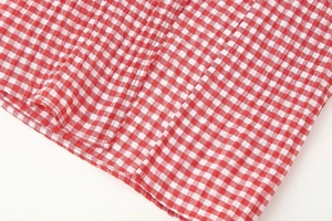 Detailed view of red and white gingham fabric with seersucker textured finish