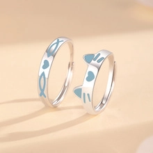 Detailansicht der silbernen S999 Paar-Ringe mit süßem Katzen- und blauem Fischdesign