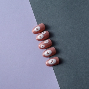 Detail of 5D white butterfly and heart embossed patterns on pink glitter press-on nails