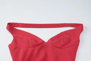 Close-up of red V-neck dress detail showing elastic pleated straps and fabric texture