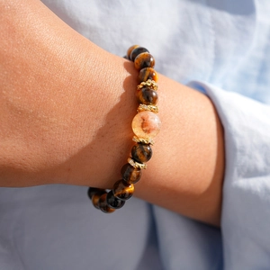Close-up of tiger eye beaded bracelet with zircon crystal and golden metal spacers
