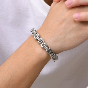 Detailed macro shot of men's chunky stainless steel Byzantine chain bracelet on wrist