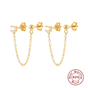 Close-up of gold 925 sterling silver chain earrings with zircon and silver hallmark