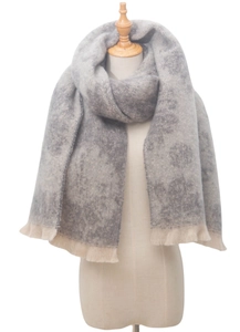 Detail showing the gray and beige gradient floral pattern and soft fringe of the scarf
