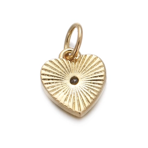 Close-up of golden heart pendant with sunburst texture and dark center gemstone