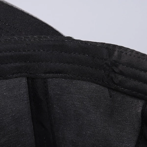 Detailed macro view of black cotton baseball cap showing reinforced double-stitch seams