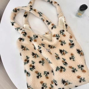 Close-up of floral plush tote bag showing soft sherpa texture and colorful brand label