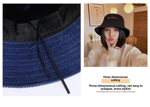 Detail of black corduroy bucket hat showing orange embroidery and adjustable inner drawstring