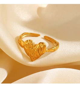 Macro shot of gold heart ring with crumpled texture and adjustable open band on silk