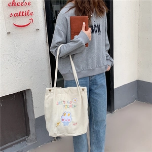 Détail du sac cabas en velours côtelé avec broderie lapin et fermeture par bouton pression