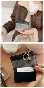 Detail of slim card holder with black leather, grey fabric, and gold keychain ring