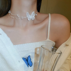 Gros plan d'un choker papillon en organza avec perles sur cou de mannequin pour look élégant