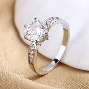 Detailed macro shot of silver ring with six-prong set round zircon and side stones