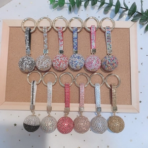 Flat lay of colorful crystal ball keychains with rhinestones and ribbon accents