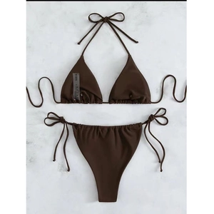 Flat lay of brown ribbed triangle bikini set with side tie bottoms on marble