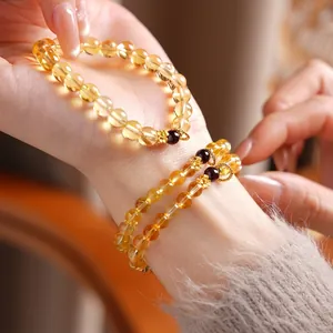 Elegant citrine and garnet flower charm bracelet with translucent yellow beads and gold accents