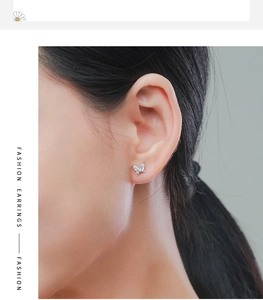 Gros plan de boucles d'oreilles papillon en argent S925 avec zircons sur un mannequin