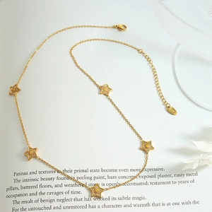 Gold star necklace set with zircon stones and 18K plating on minimalist book page