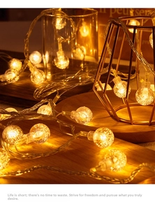 Detail view of warm yellow solar star string lights wrapped around geometric metal frames