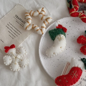 Close-up of wool felt Christmas stockings and stars with gold embroidery and velvet bows