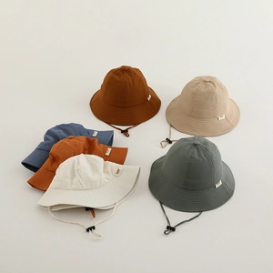 Détail de plusieurs bobs pour enfants en couleurs unies avec mentonnières réglables