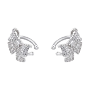 Detailed view of silver bow-shaped ear cuffs encrusted with sparkling zircon stones