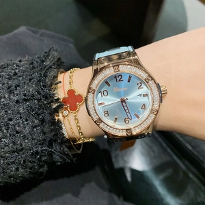 Elegant gold-tone women's quartz watch with blue rhinestone dial and calendar on wrist