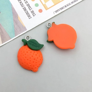 Close-up of resin orange fruit charms with metal loops for DIY jewelry making
