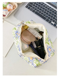 Interno di trousse trapuntata con fiori blu su base bianca posizionata sulla scrivania