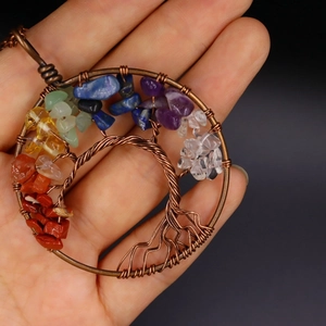 Detailed macro view of handmade bronze Tree of Life pendant with seven chakra natural stones