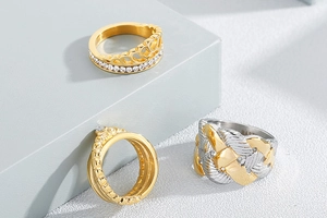 Detailed view of three vintage gold rings with rhinestones on geometric display stands