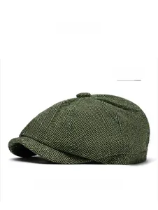 Close-up of green herringbone newsboy cap fabric texture and top button detail