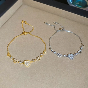 Detail of adjustable hollow heart bracelets with zircon stones in gold and silver finish