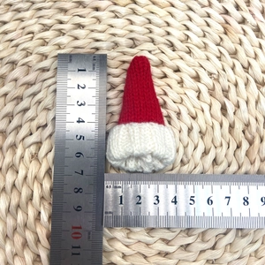 Gros plan d'un mini bonnet de Noël tricoté de 7cm avec bordure en peluche blanche