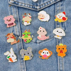 Set of 12 cartoon Chinese Zodiac animal enamel pins pinned on a denim jacket pocket
