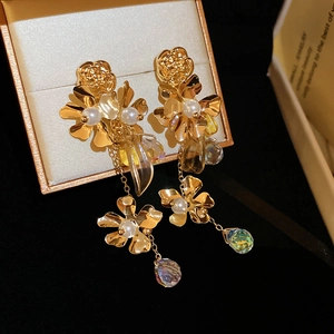 Detailed shot of gold floral earrings with tassels and pearls in a luxury jewelry box