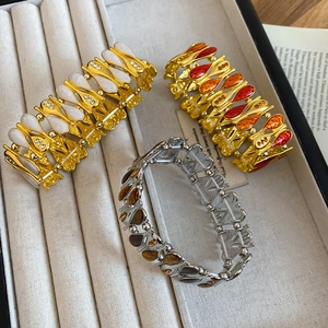 Three vintage enamel bracelets with crystal accents and teardrop patterns on a tray