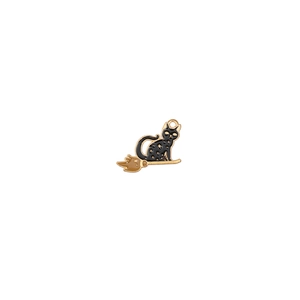 Macro shot of an enamel black cat pendant on a golden broomstick for DIY jewelry